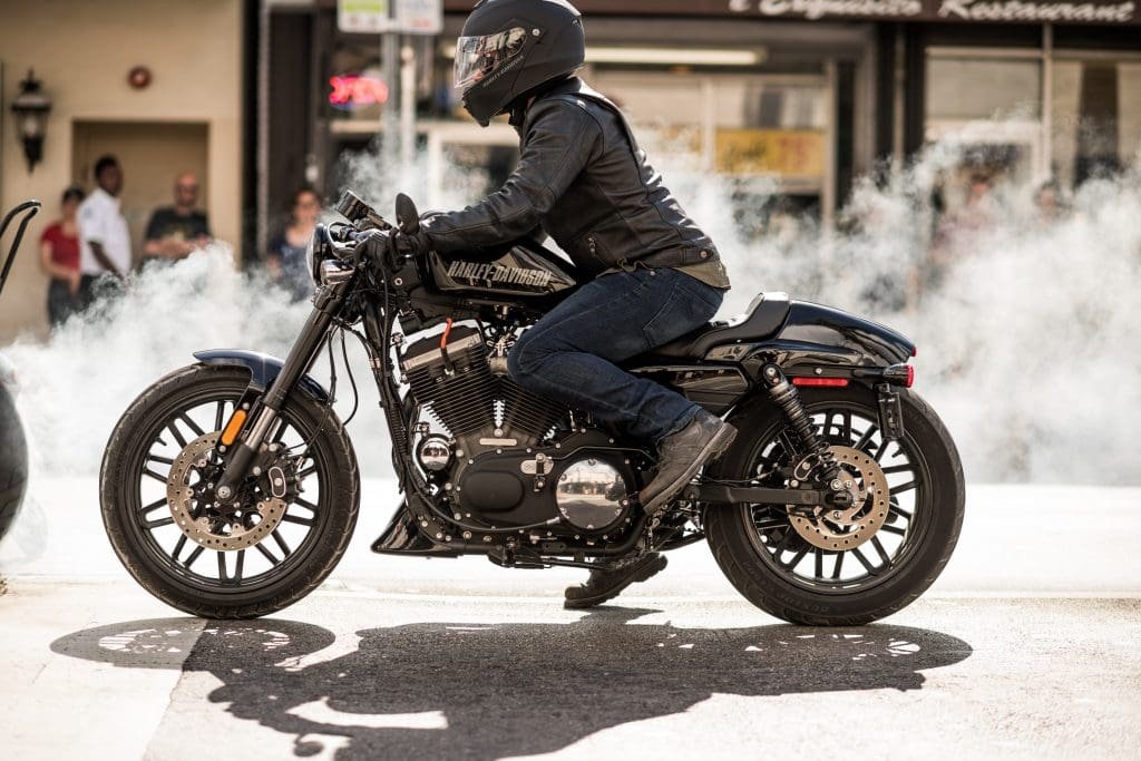 A motorcyclist wearing a helmet and leather jacket