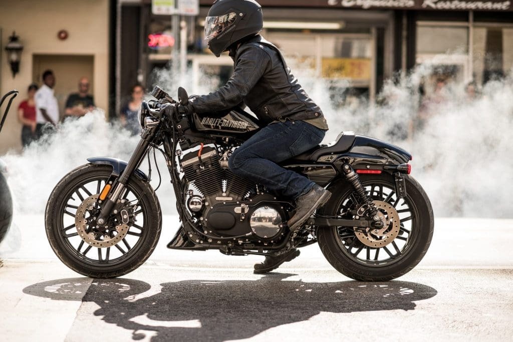 A motorcyclist wearing a helmet and leather jacket