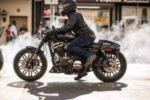 A motorcyclist wearing a helmet and leather jacket