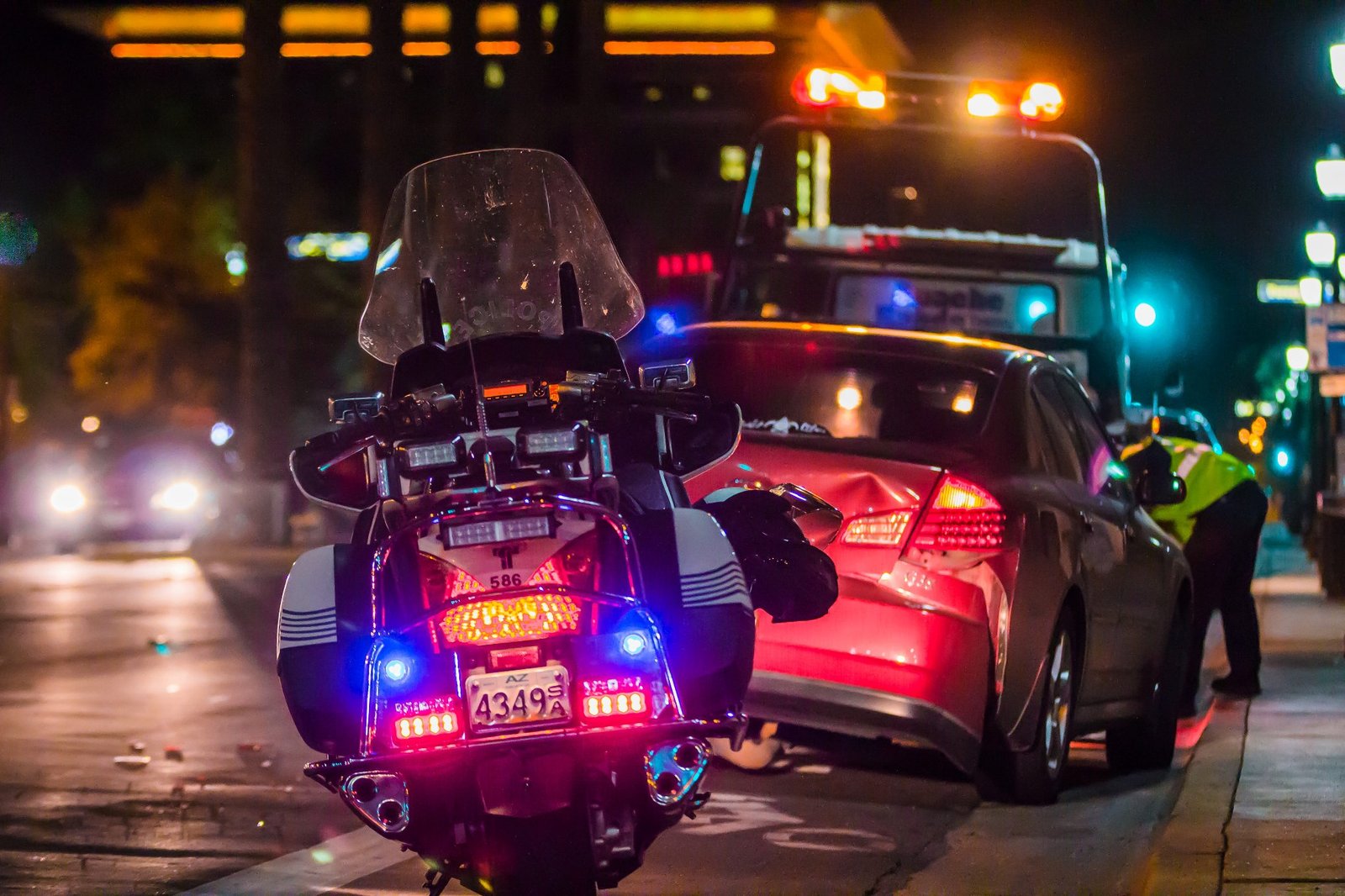 Police motorcycle stopped near a tow truck