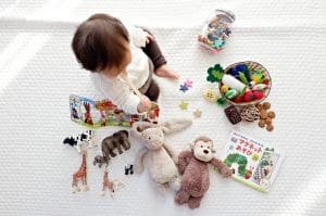A toddler interacts with colorful toys and storybooks