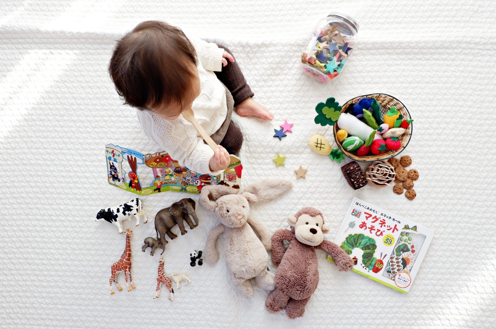 A toddler interacts with colorful toys and storybooks
