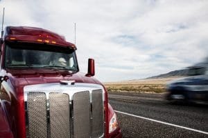 a red semi-truck is parked on a highway