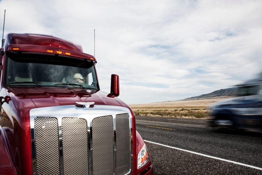 a red semi-truck is parked on a highway